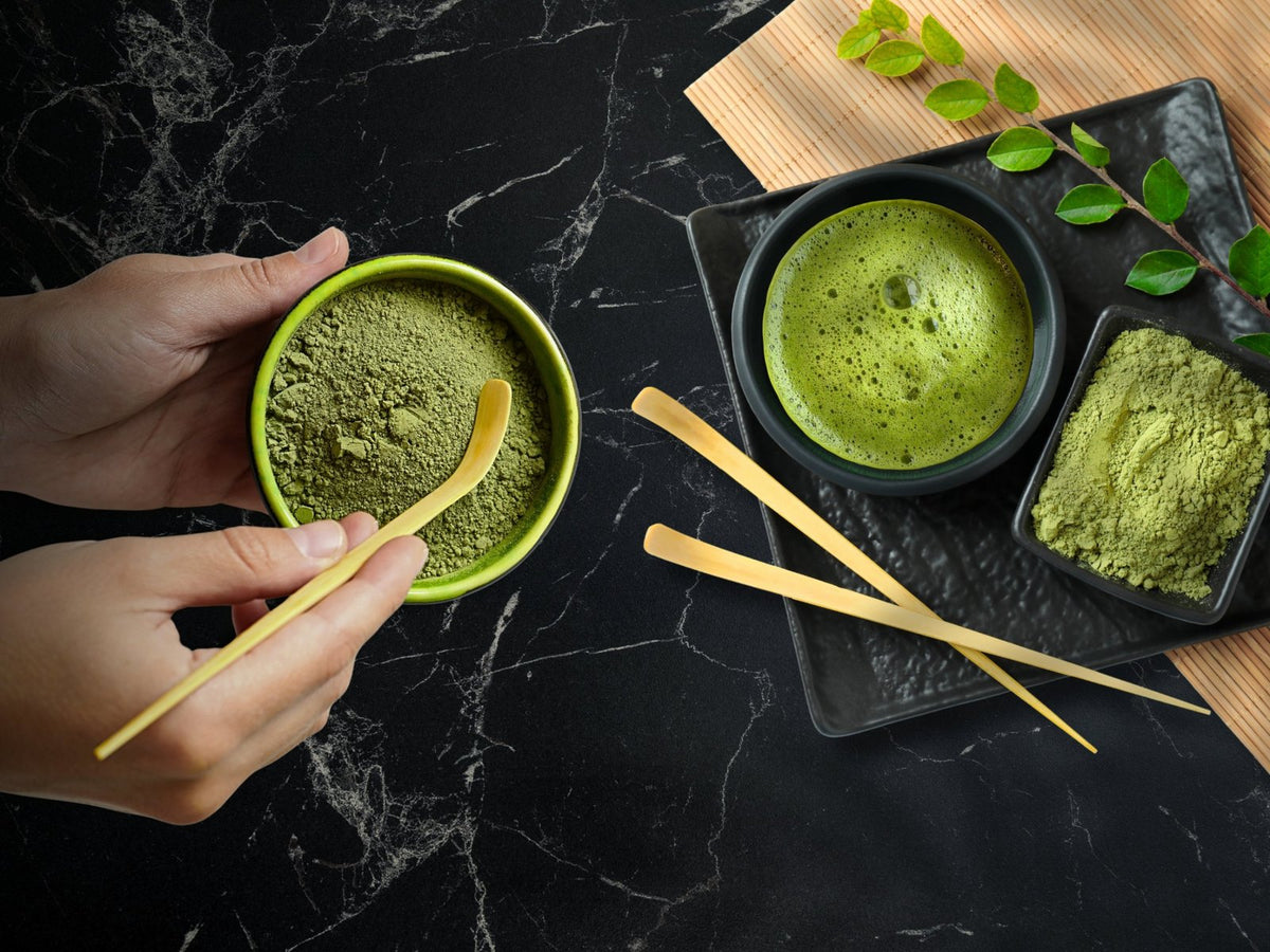 Hands whisking ceremonial matcha in a bowl