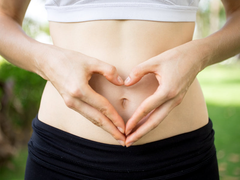 Hands forming a heart shape over the stomach