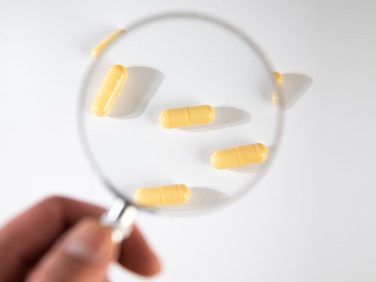 Magnifying glass over supplement capsules